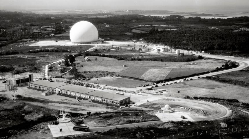 Radôme, vue d’ensemble des premières installations. Cette photographie prise en altitude permet de situer géographiquement l’ensemble du projet, à proximité de la côte de granit rose, édifié sur des landes de faible valeur. Le radôme est relié à un centre technique établi un peu plus haut sur le plateau. © Cité des télécoms Cnet Service des essais en vol.