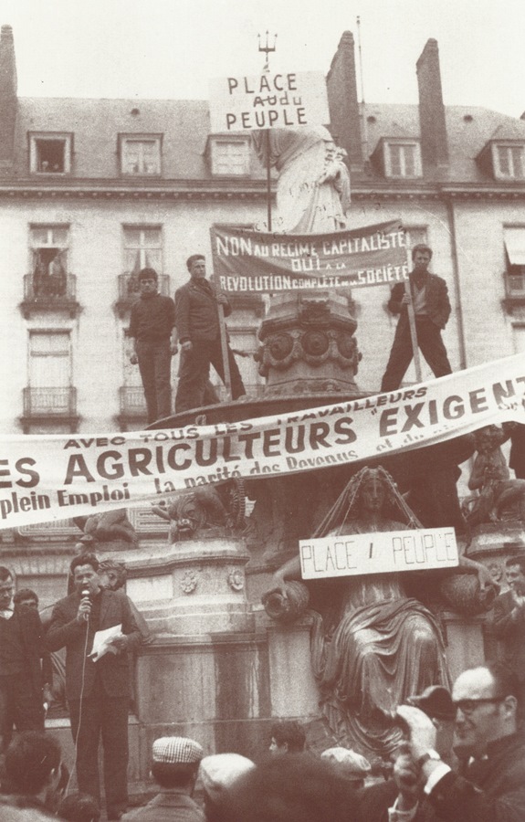 La fontaine de la place Royale à Nantes avec une prise de parole de Emmanuel Charriau (président FDSEA 44) et à gauche (à la droite de Charriau), Bernard Thareau, enfin, complètement à droite, Bernard Lambert applaudit. [CHT, coll. journal Le Paysan nantais]