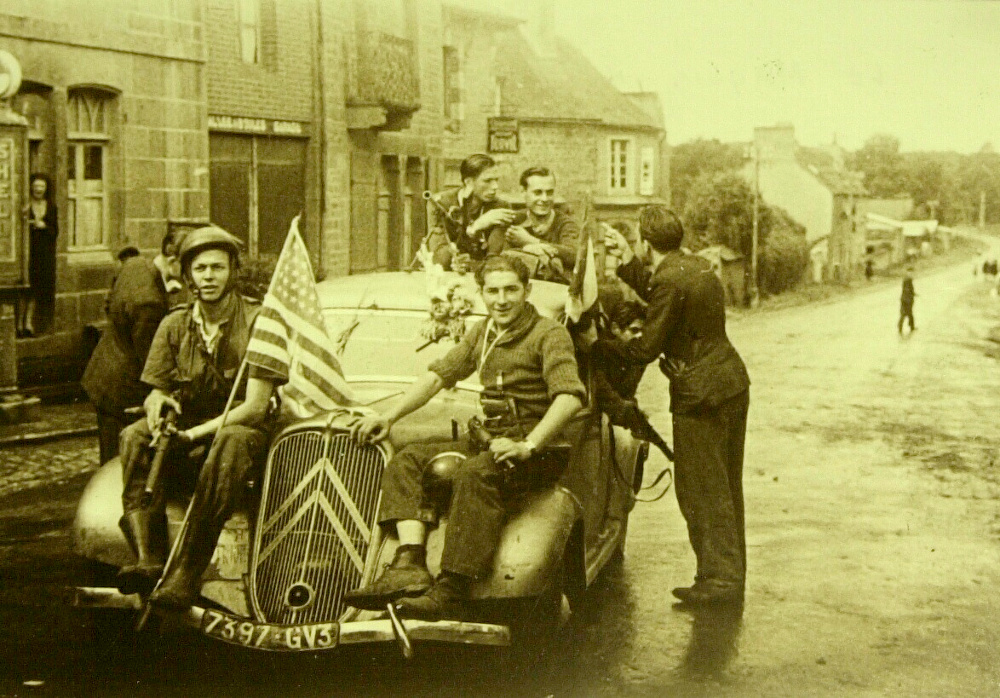 À Merdrignac (Côtes-du-Nord), le jeudi 3 août 1944, le maquis de Creneleu sort de la clandestinité. Image emblématique de la Libération de la Bretagne, des FFI armés de sten parachutées par les Alliés et circulant à bord d'une traction avant Citroën sans doute réquisitionnée, posent pour la photo à Merdrignac. Source : © Collection OBC / Musée de la Résistance en Bretagne - photo Yves Moisan - DR